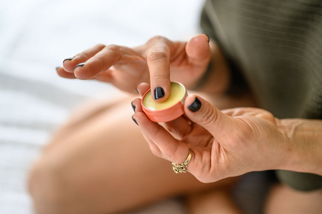 Person holding a Kenna Nicole Balm with a white background